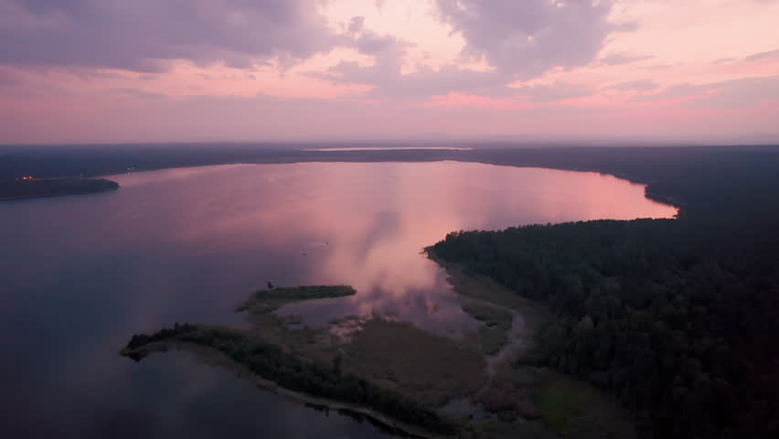 Fog rolling over a lake at sunrise aerial view