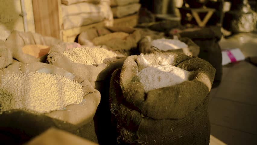 Sacks filled with different grains and flour displayed in a traditional market shop