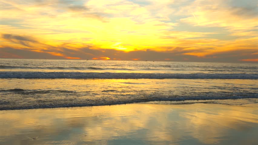 Golden sunset over Pacific Ocean waves on Santa Monica beach