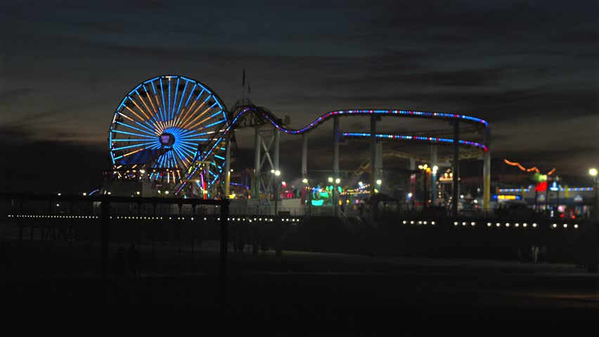 Santa Monica Pier ferris wheel and roller coaster at night over ocean