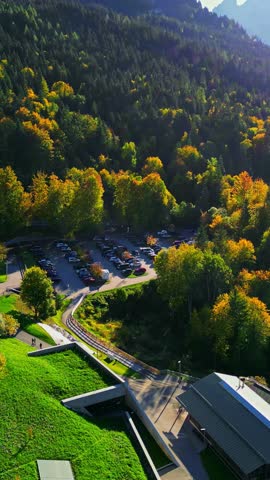 Elevated perspective of autumn forest with structures and parking lot