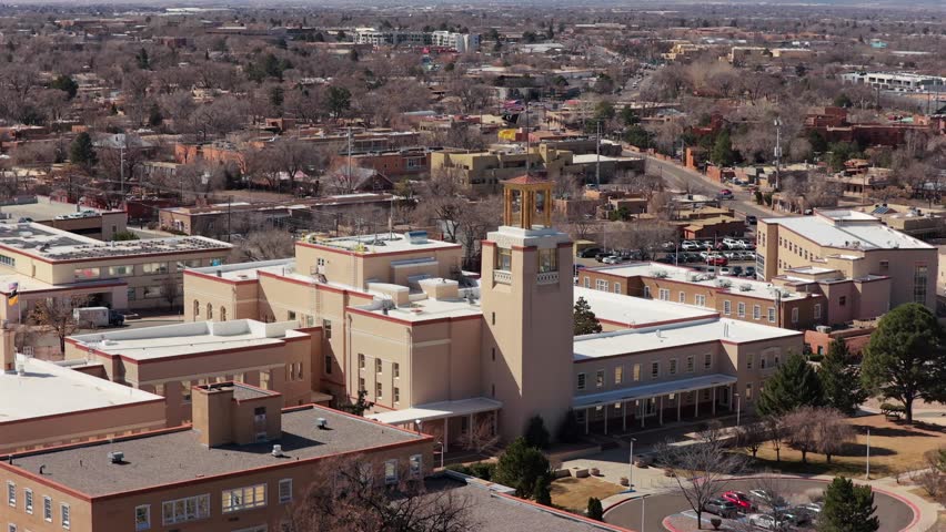 A smooth aerial orbit showcases the unique Southwestern architecture of the New Mexico State Capitol. This 4K perspective highlights the building