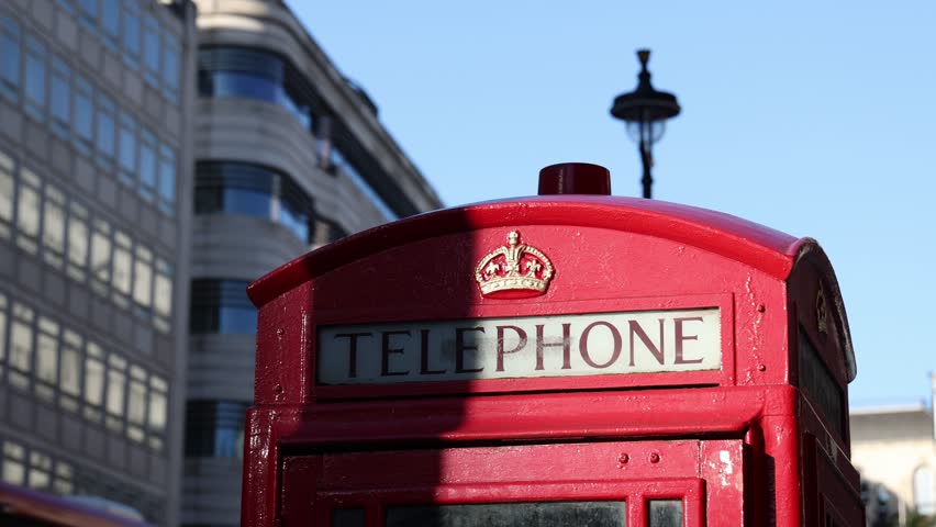 Red street telephone booth in England, establisher b roll