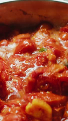 Cooking Sicilian food red peeled tomatoes in a pot