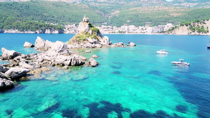Aerial drone view of wild Adriatic coastline between Budva and Bar in Montenegro, turquoise sea waves touching hidden beaches and rugged mountains, pristine Mediterranean nature landscape under clear blue sky, dramatic coastal adventure travel scenery captured in cinematic 4K – 02 October 2026