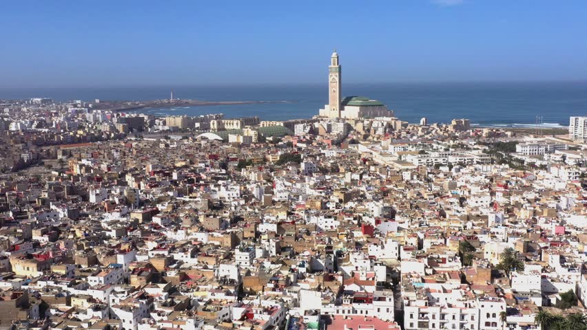 Wide aerial view of Casablanca Morocco featuring Hassan II Mosque by the Atlantic coast showcasing iconic Islamic architecture and urban cityscape