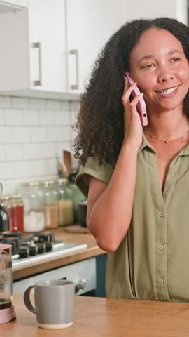 Smiling Black Woman with Natural Hair Enjoys a Cheerful Phone Conversation in Her Modern Kitchen