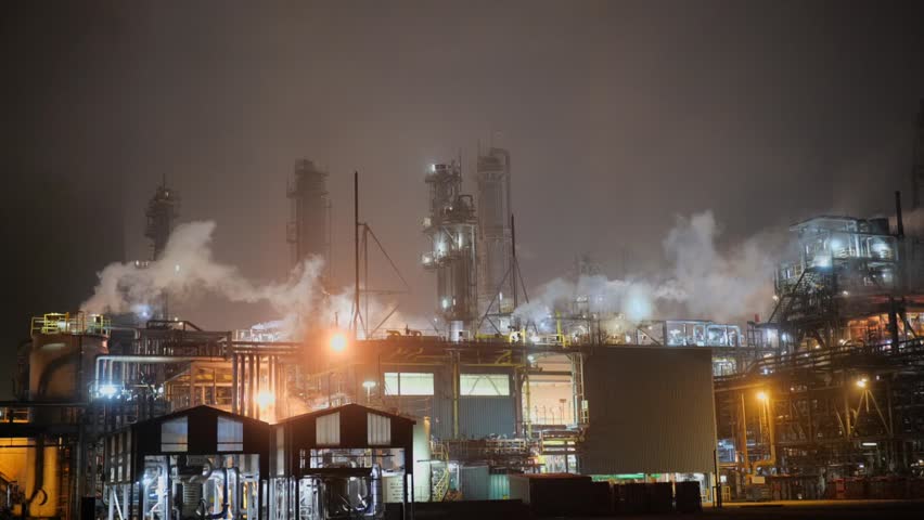 Oil Refinery at night, steam and smoke.  