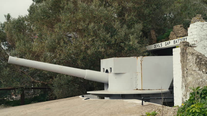Historic artillery cannon at Devil’s Gap Battery on the Rock of Gibraltar, surrounded by greenery and defensive stone walls.