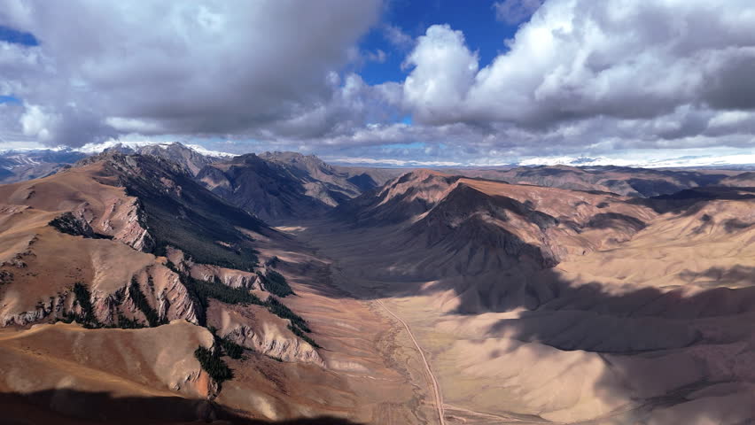Mountain Landscape With Remote Valley Road And Snow Peaks