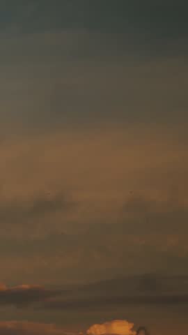 Flockfilled dusk sky with scattered birds, warm gradient from blue to amber, wide expanse and gentle cloud