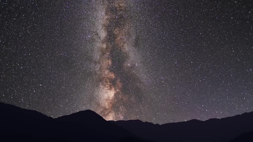 Night landscape, mountains under bright colorful milky way galaxy. Space, night scene time lapse.