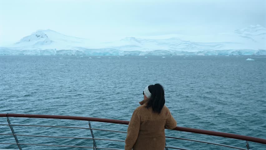 Girl On Expedition Cruise At Bow Looking Out At Antarctica Landscape