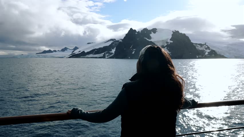 Girl On Expedition Cruise Balcony Looking Out At Antarctica Landscape