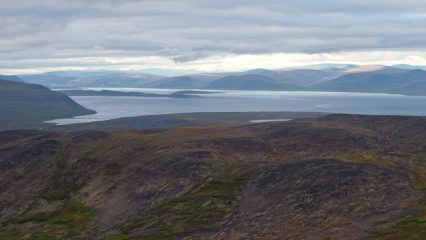 Lavrentiya Bay opens to the Arctic with islands and broad water under layered cloud. Gentle light and clean air form a calm coastal mood. Great for travel, port story, climate narrative, remote settle