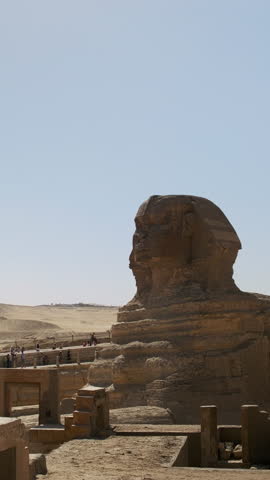 The Great Sphinx monument at the Giza Plateau under a clear desert sky. The ancient limestone statue with the body of a lion and the head of a pharaoh dominates the arid landscape