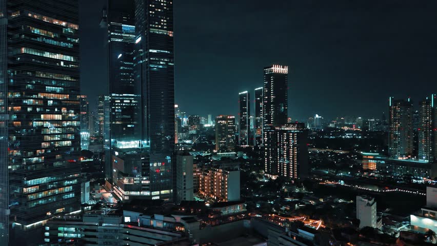Jakarta city lights at night with moving traffic trails and illuminated skyscrapers. Stunning urban skyline of Indonesia’s capital city showing modern architecture and vibrant nightlife.