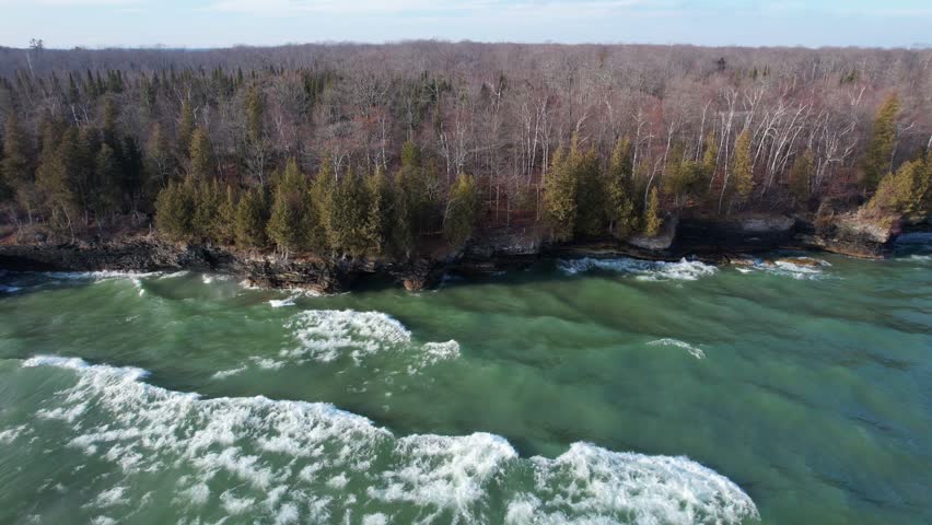 Aerial view of Lake Michigan coast line in Door County Wisconsin.  Drone over rugged shore with waves crashing.