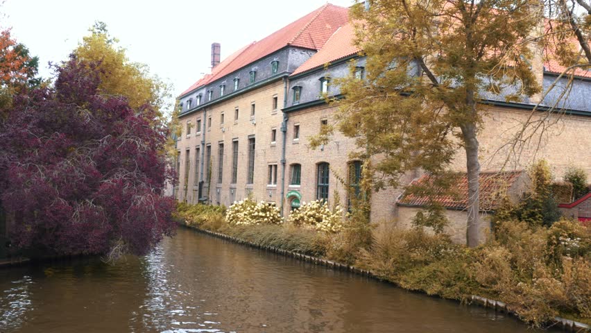Bruges, Belgium. Medieval architecture on the banks of a river in the historic center of Bruges. High-quality 4K video.
