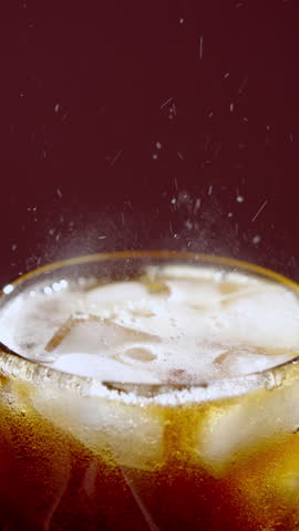 Closeup of chilled soda and icy sparkle. Photograph showcasing bubbly soda pouring over ice with vibrant backdrop and refreshing summer feel