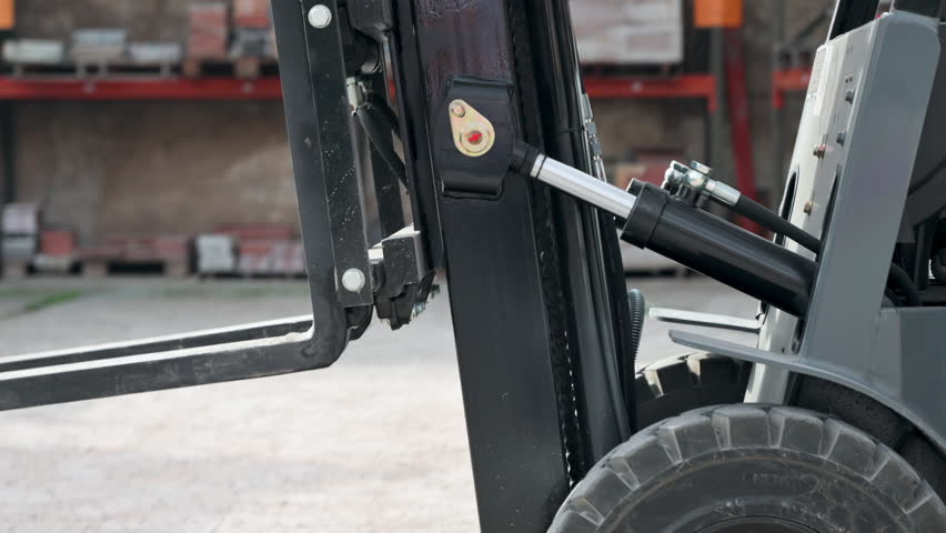 Forklift lowering forks close up in warehouse, industrial lifting equipment operation. High quality 4k footage