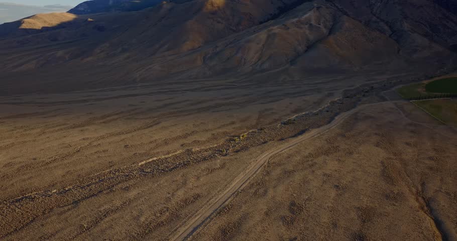 Winding roadway through broad Idaho valley with Borah Peak in distance