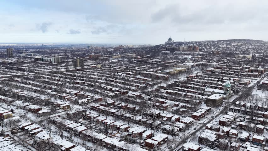 Aerial winter view of snow covered residential rooftops and brick houses in Montreal, Quebec, Canada urban neighborhood. g.