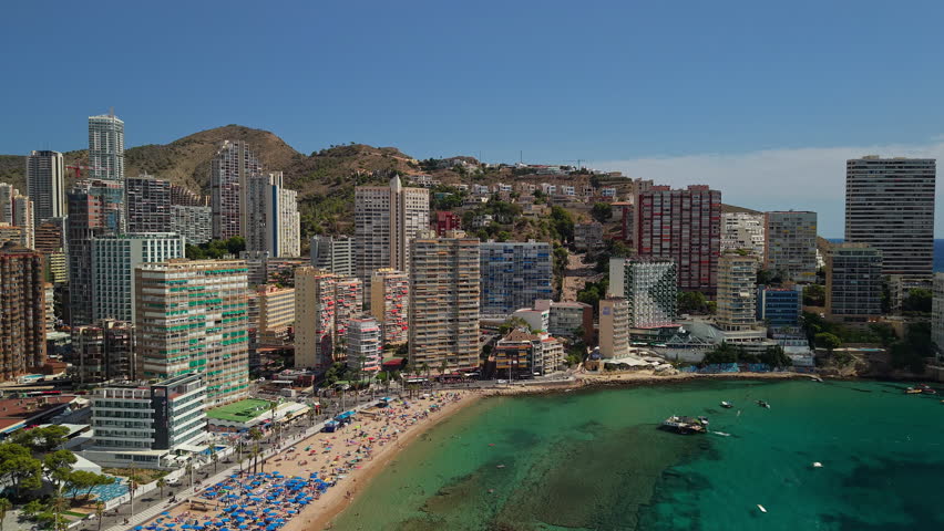 Aerial view of Benidorm coastal bay with beachfront buildings, sandy beach and turquoise Mediterranean water Spain. High quality 4k footage