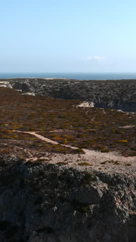 Coastal Trail View. Quiet Footpath Traversing Heath And Rocks Towards Expansive Ocean Panorama And Solitude . Media