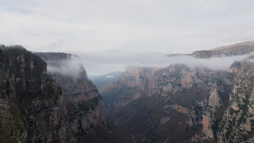 Misty cliffs of Vikos Gorge in Epirus Greece, establshing natural landscape backdrop