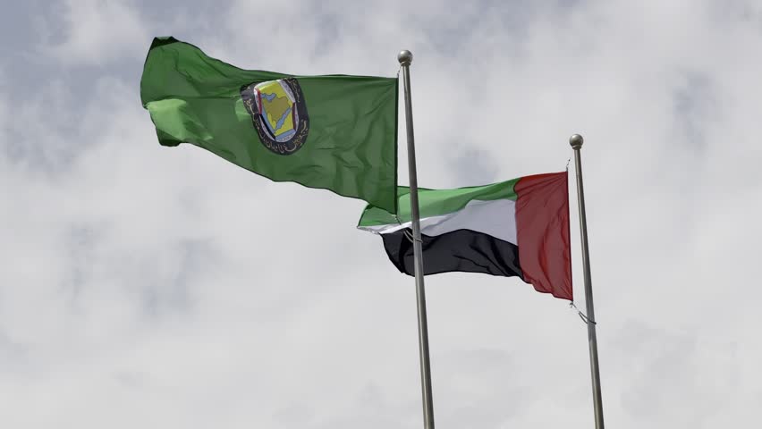 A close‑up of the GCC and UAE flags waving, symbolizing unity at the Saudi–UAE desert border