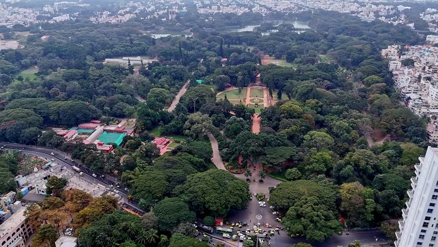 Aerial drone view capturing Lalbagh Botanical Garden in Bengaluru with vibrant greenery, tree canopies, pathways, and landscaped gardens highlighting the natural beauty of the city