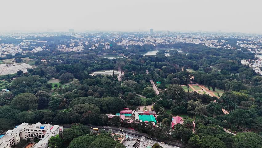 Aerial footage of Lalbagh Botanical Garden in Bengaluru showing dense greenery and the iconic Glass House, within gardens originally commissioned by Hyder Ali centuries ago