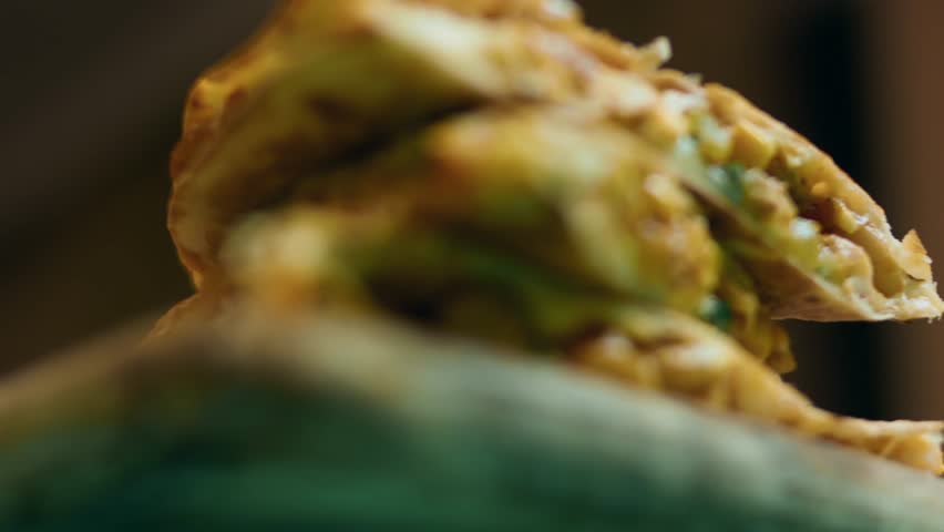 Slices of vegetable quesadilla on a wooden surface
