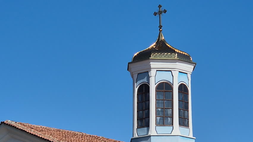 Facade of a Christian church in a sunny day with blue sky, zoom out