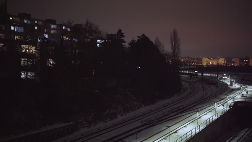 Train at night going through city at winter time