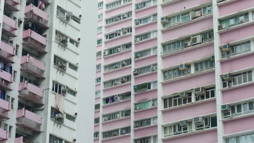 Panoramic view of apartment buildings and skyscrapers in downtown Hong Kong, China on a sunny day, showcasing dense urban living and modern architecture.