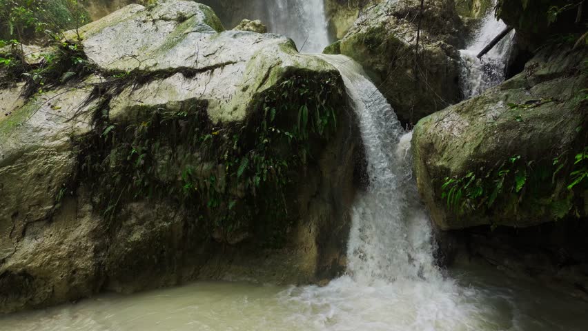 Cinematic of Inambakan Falls with muddy water and rocky textures, Philippines