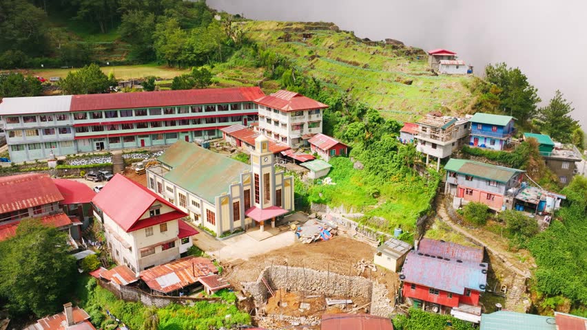 Sun breaks through clouds illuminating Atok parish nestled in green hills