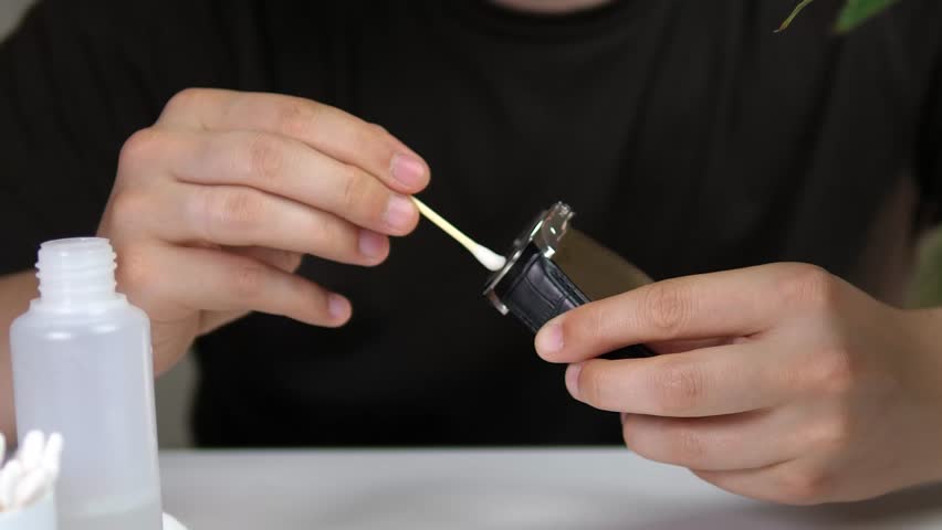 Close-up of DIY Wristwatch Restoration Process. Detailed video of cleaning a black leather watch strap and silver case. Skilled hands performing delicate maintenance. Ideal for tutorials, repair