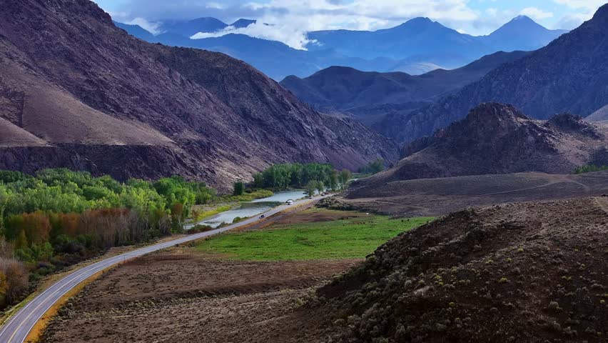 Highway 93 crossing broad valley with river and mountain range in Idaho