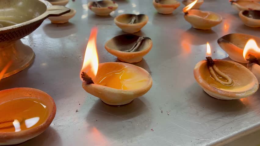 Diwali style small clay temple candles burning close up view