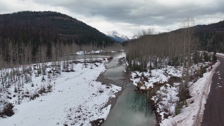 Aerial view down winter Flathead River through mountains of Montana