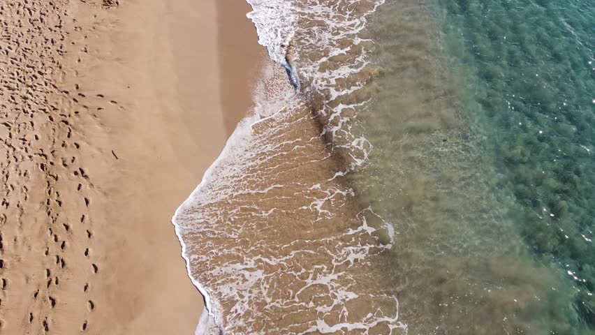 Ocean waves crashing lightly during a beautiful sunset on the beach in Maui Hawaii