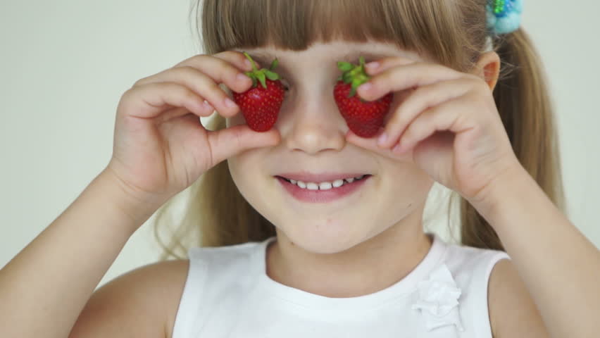 Little girl with two strawberries
