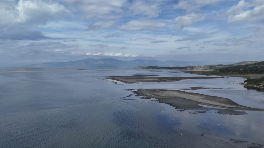 Drone aerial view of flock of birds flying over the Aegean Sea near Kusadasi Turkey with Samos island visible on horizon.
