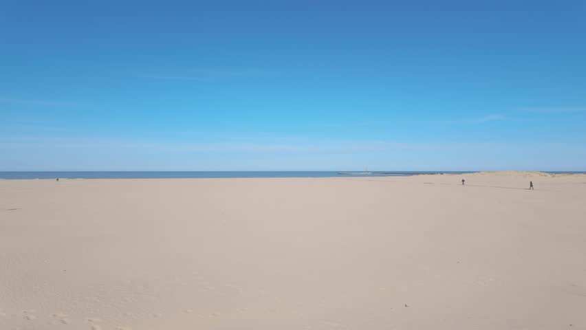 Pedestrians walk on the beach trail to Lake Michigan on an otherwise empty Montrose Beach in Chicago.