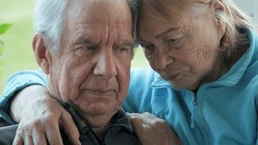 Senior couple cuddles. Older spouses hold each other lovingly inside. Aged married pair affectionately hug in cozy home. Elderly married couple shares experiencing sadness and longing from loss - Powered by Shutterstock - Get 15% off with code: PIKWIZARD15