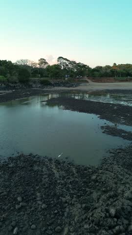 Shallow water laps over dark, wet rocks