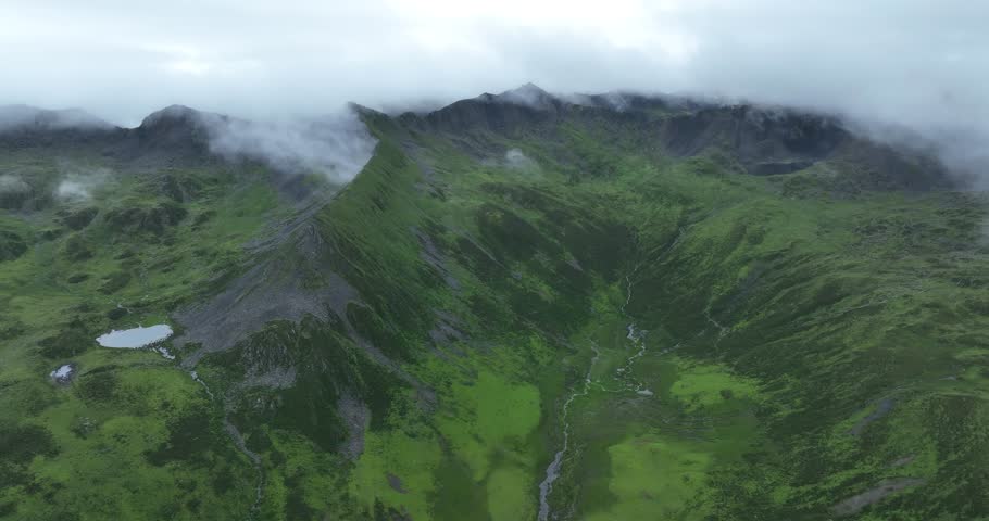 Aerial footage of beautiful high altitude grassland and mountain landscape
